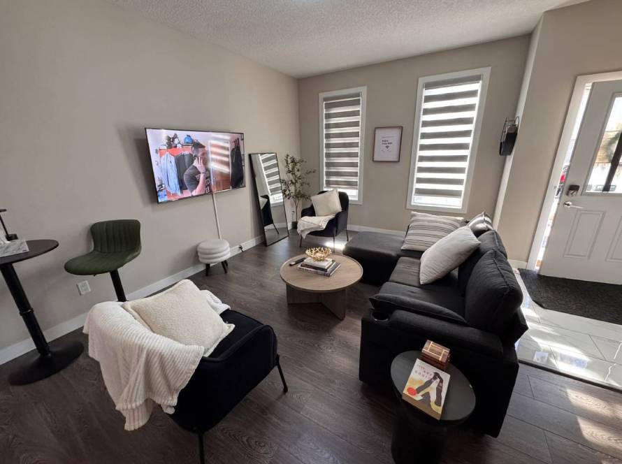 Modern living room professionally cleaned and staged during Airbnb turnover, featuring fresh linens, vacuumed floors, and organized furniture.