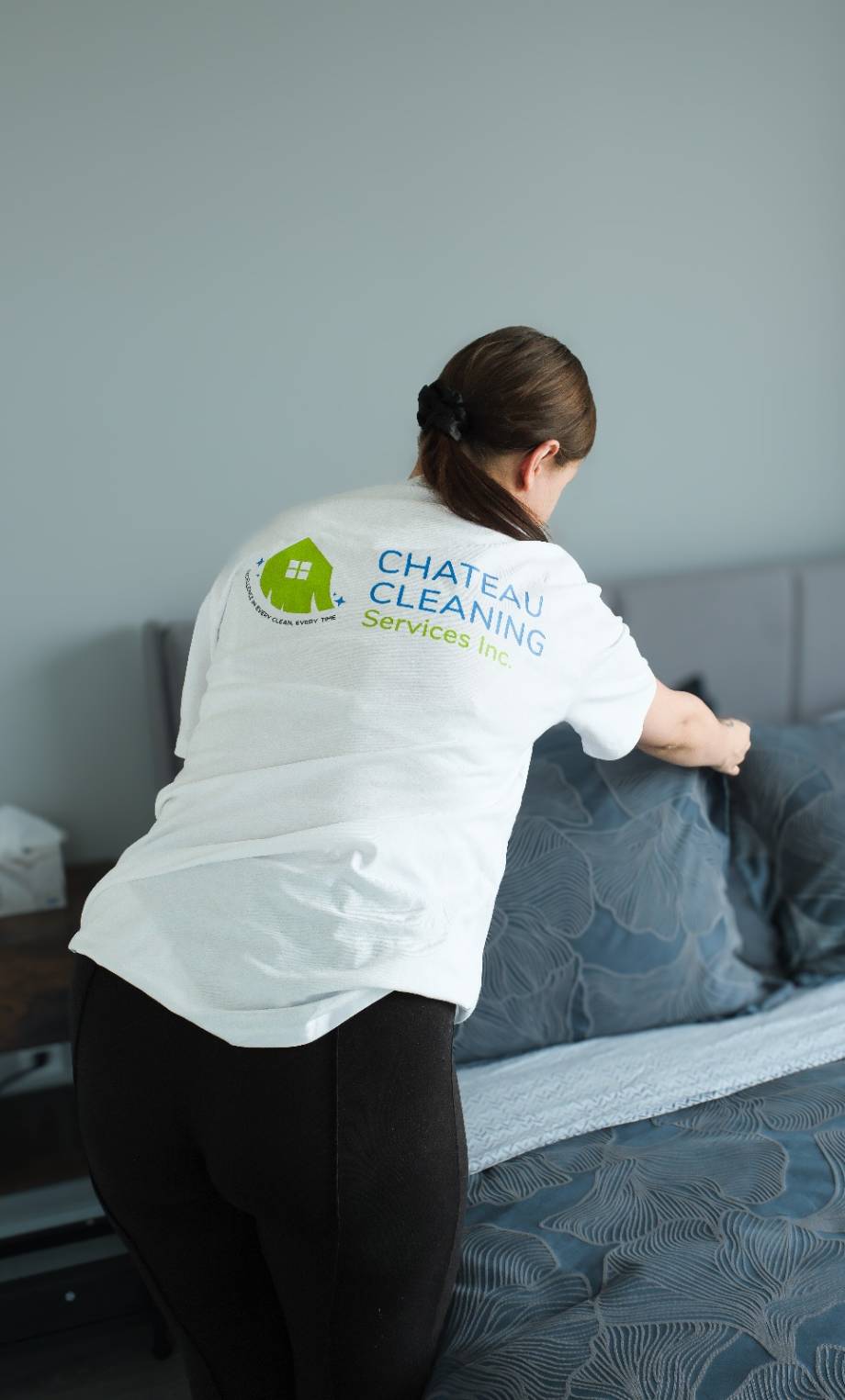 Chateau Cleaning staff preparing a freshly made bed in a tidy bedroom